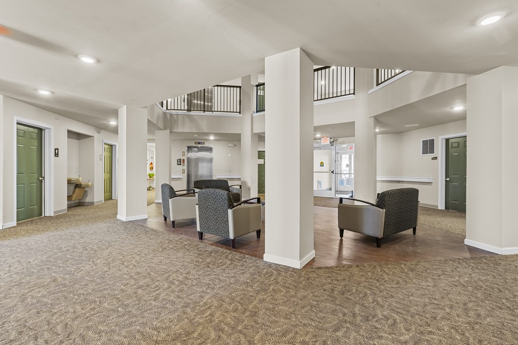 A spacious room with a carpeted floor and a balcony with a railing.