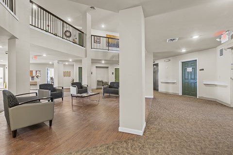 A spacious living room with a staircase and a green door.