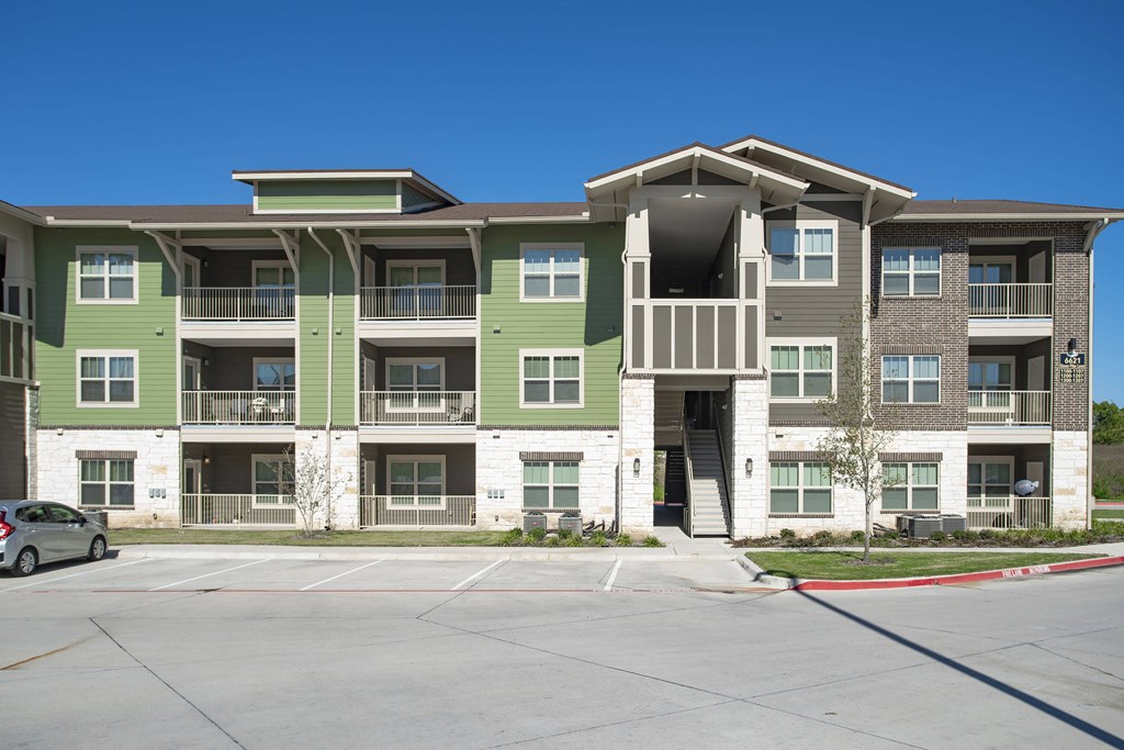 an empty parking lot in front of an apartment building