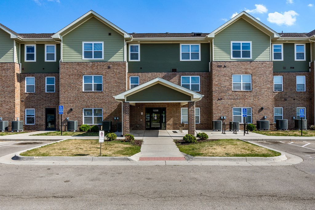 A large apartment complex with a front entrance and a roundabout.