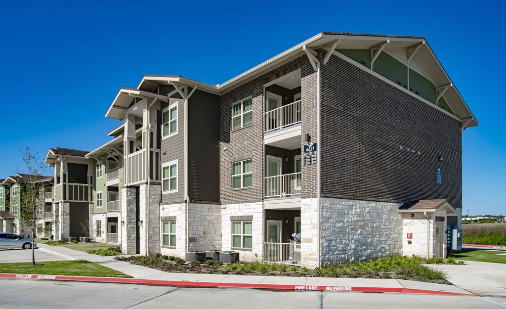 an apartment building with a street in front of it