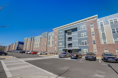 an empty parking lot in front of an apartment building