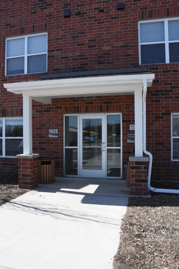 The front door of a building with a white frame and glass panels.