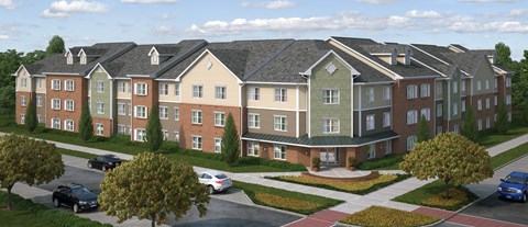 A large apartment complex with a parking lot in front.