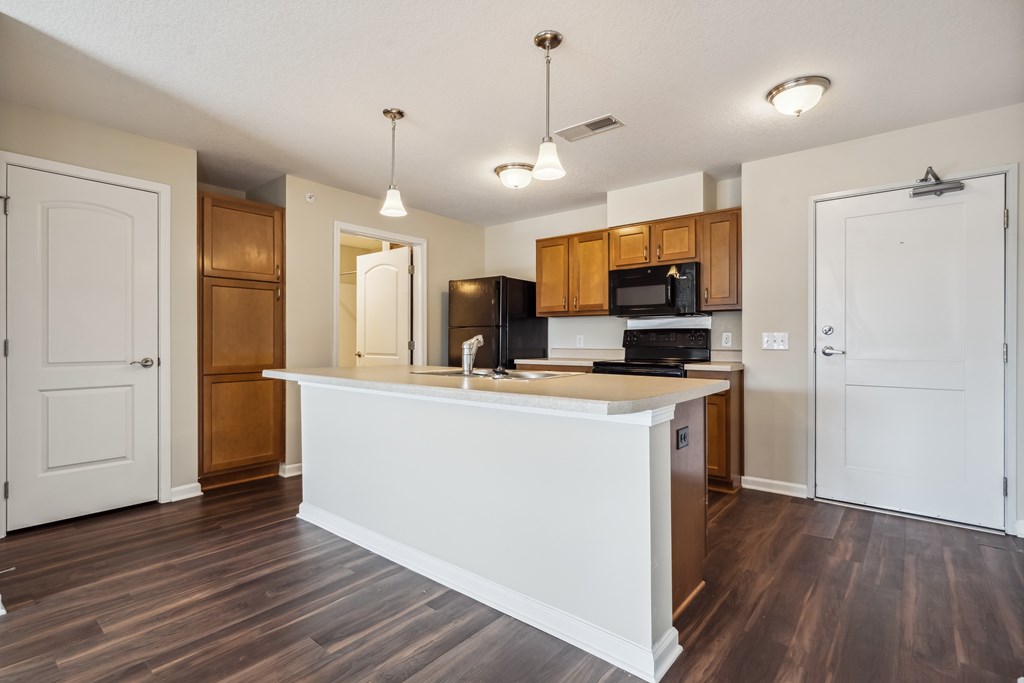 A kitchen with a white island and wooden cabinets.