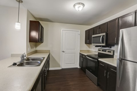 a kitchen with stainless steel appliances and dark wood cabinets
