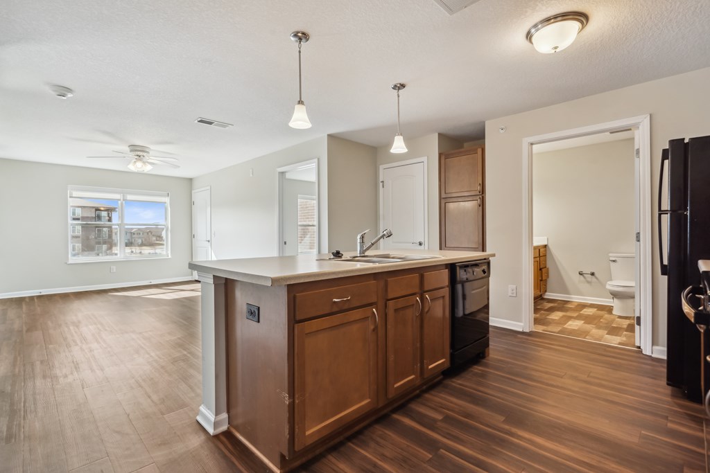 A kitchen with wooden cabinets and a black refrigerator.