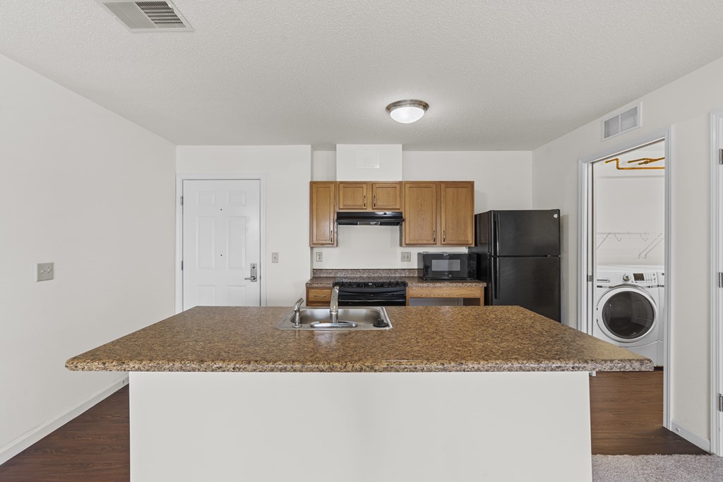A kitchen with a granite countertop and stainless steel appliances.