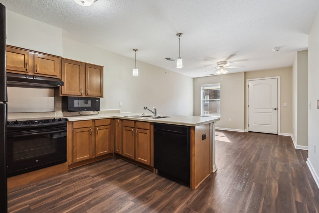 A kitchen with wooden cabinets and a black oven.