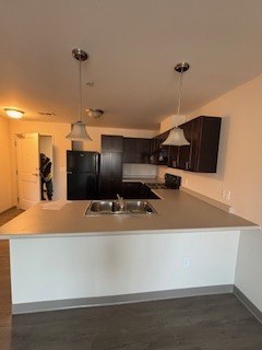 A kitchen with a black refrigerator and a white counter.