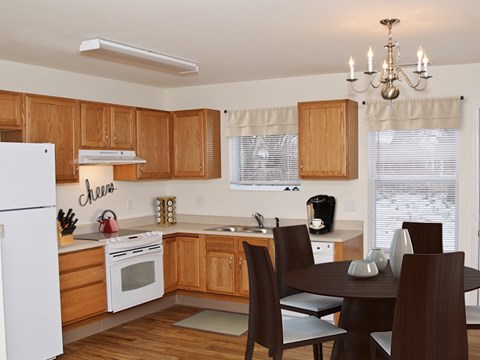 A kitchen with wooden cabinets and a white refrigerator.