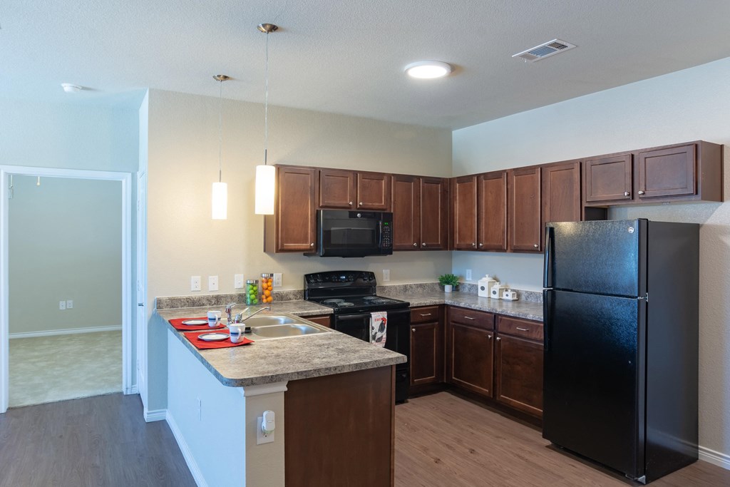 a kitchen with black appliances and a granite counter top