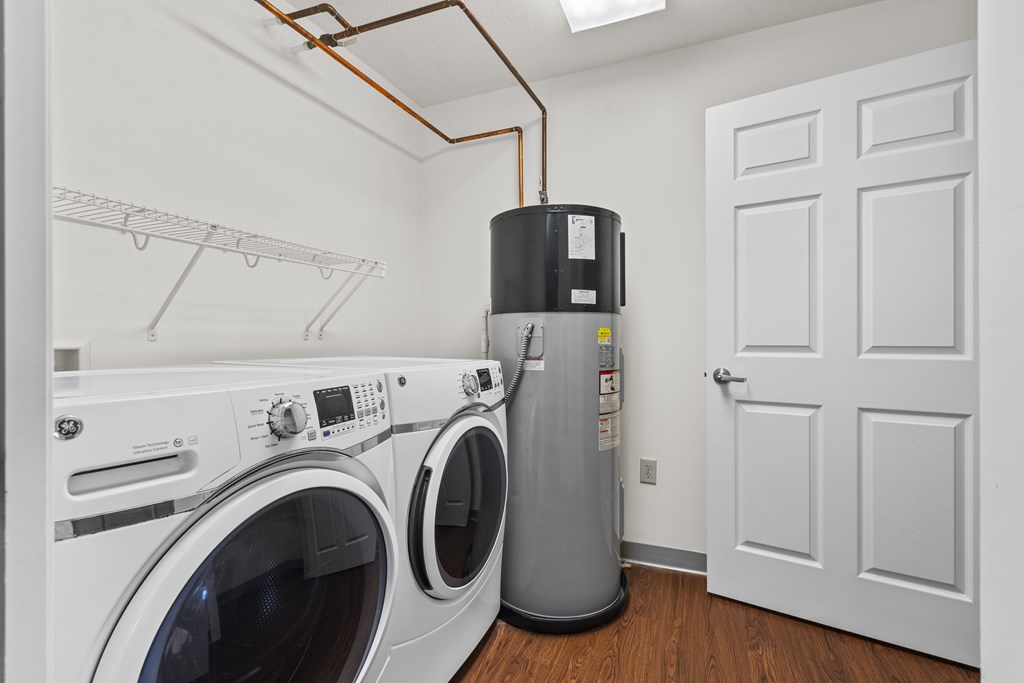 A laundry room with a washer and dryer and a water heater.