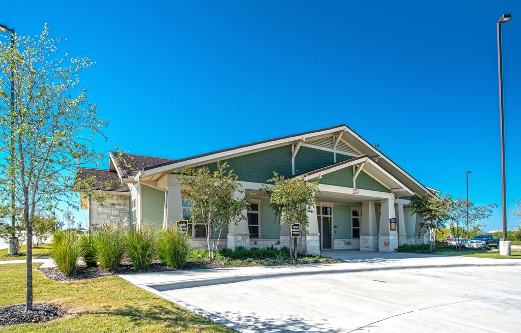 a house with a driveway and trees in front of it