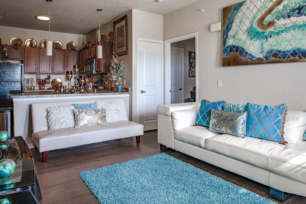 a living room with a white couch and a blue rug