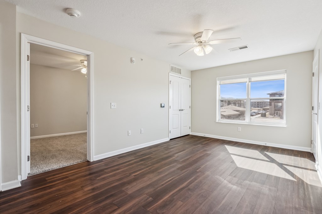 A room with a window and a ceiling fan.