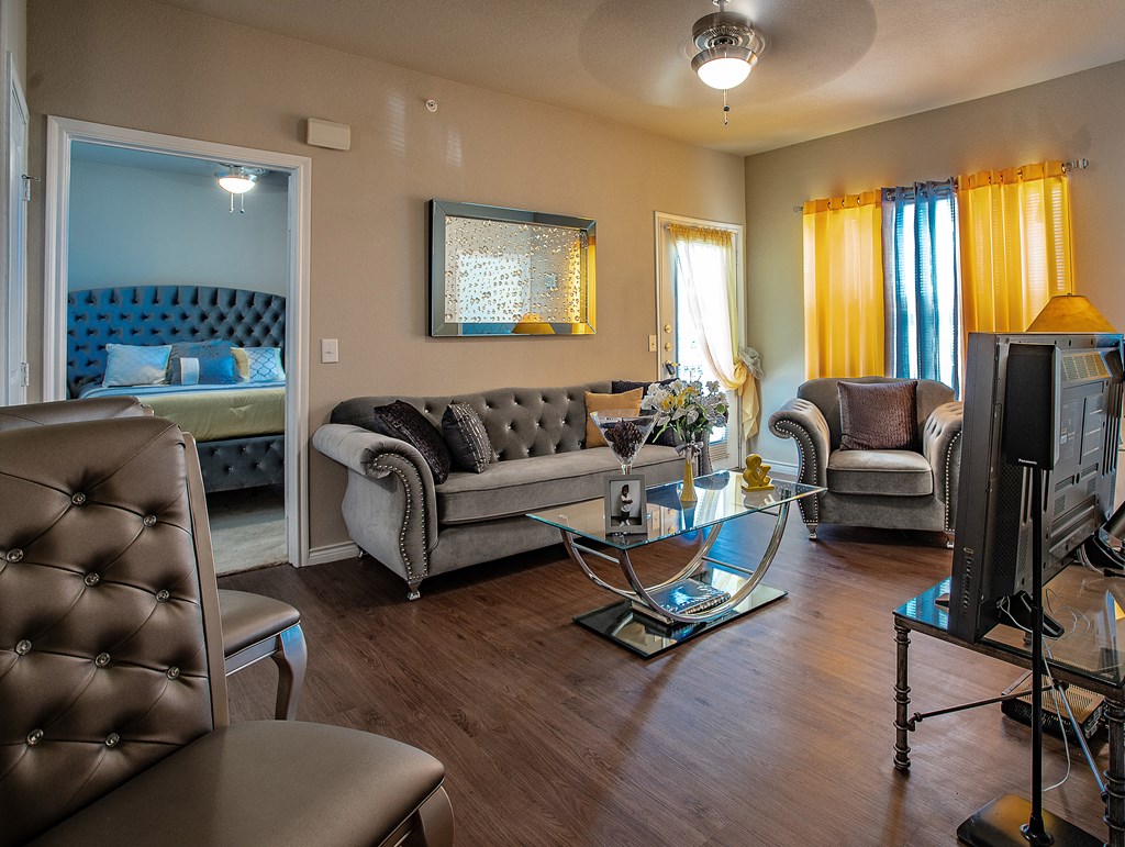 a living room with a couch and chairs and a tv