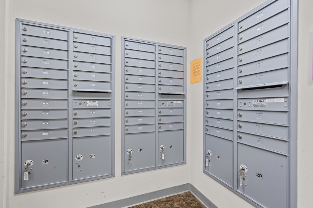 A row of mailboxes are lined up against a wall.