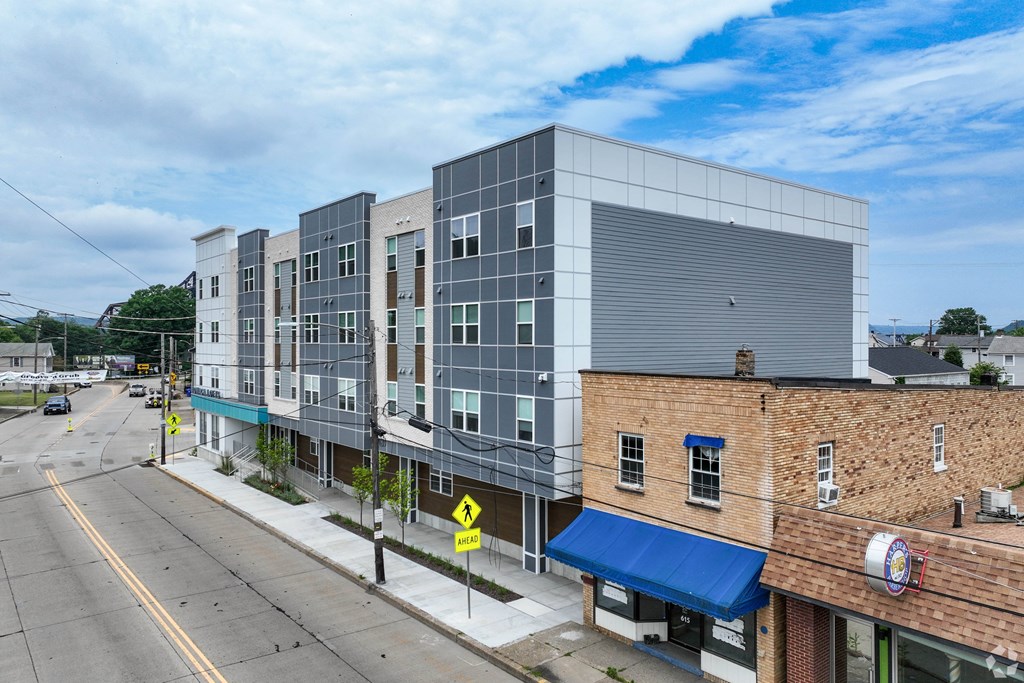 A street view of a city with a large building on the right.