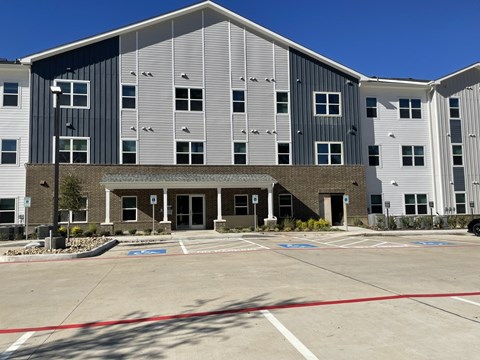 A large building with a parking lot in front.