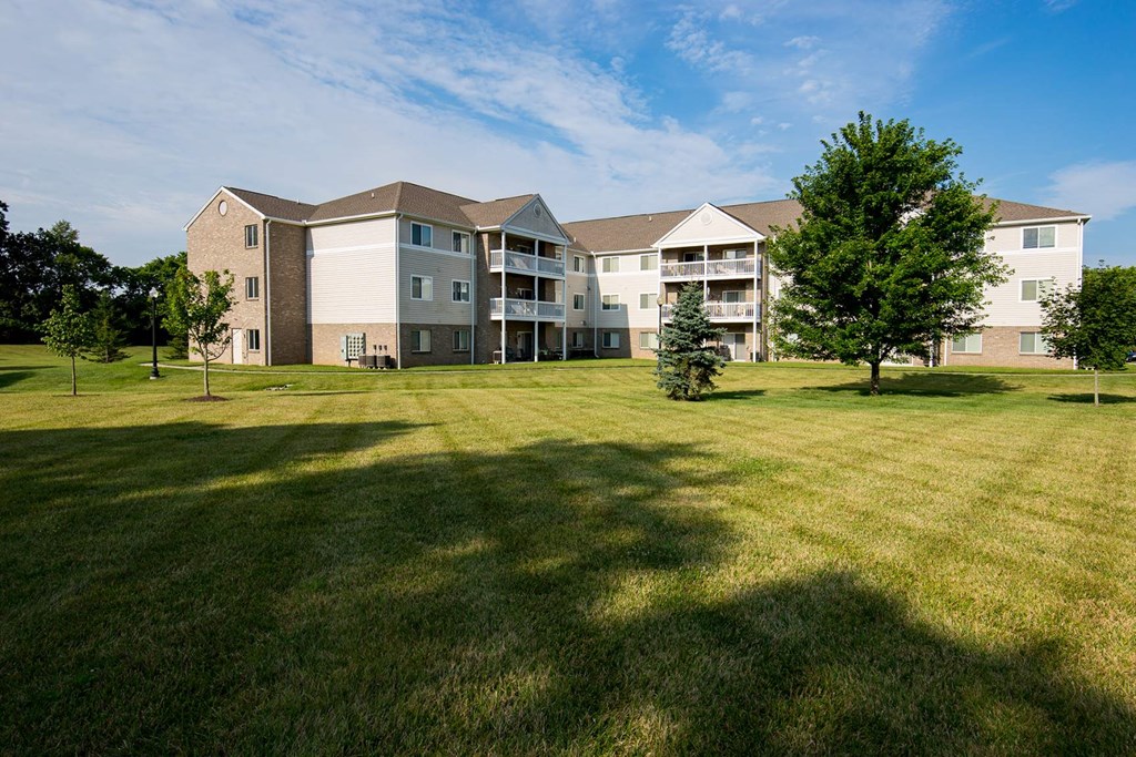A large grassy field in front of a building.