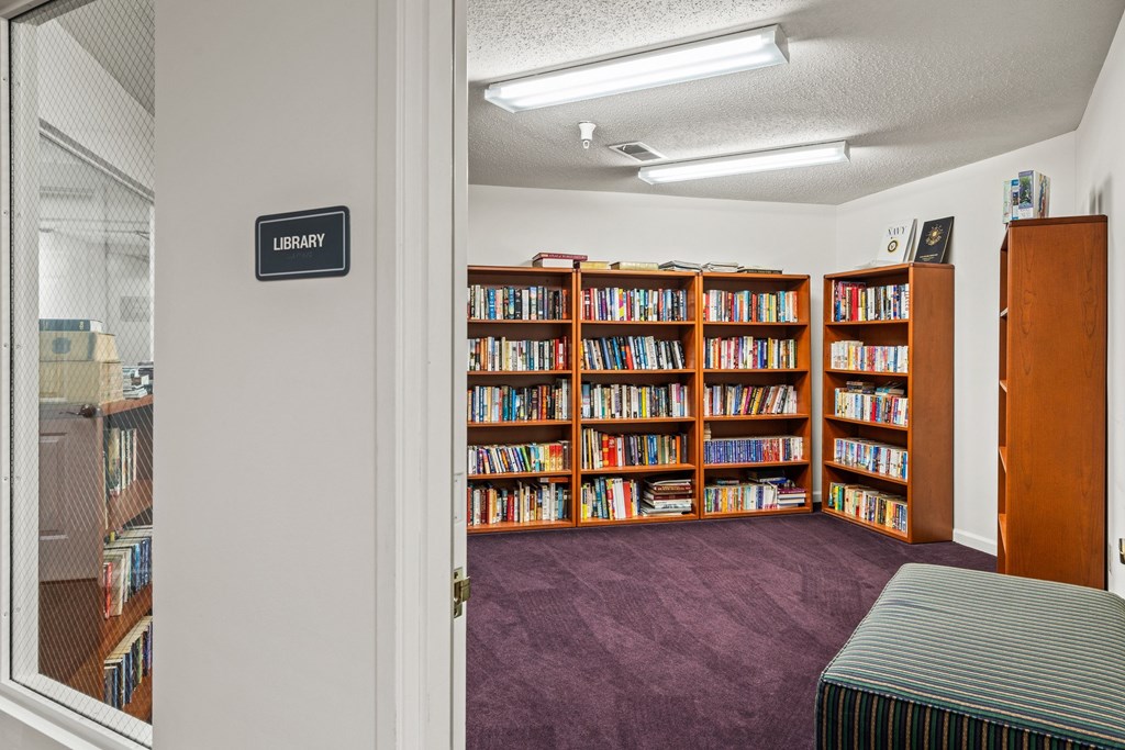 A library with a sign on the door and a carpet on the floor.