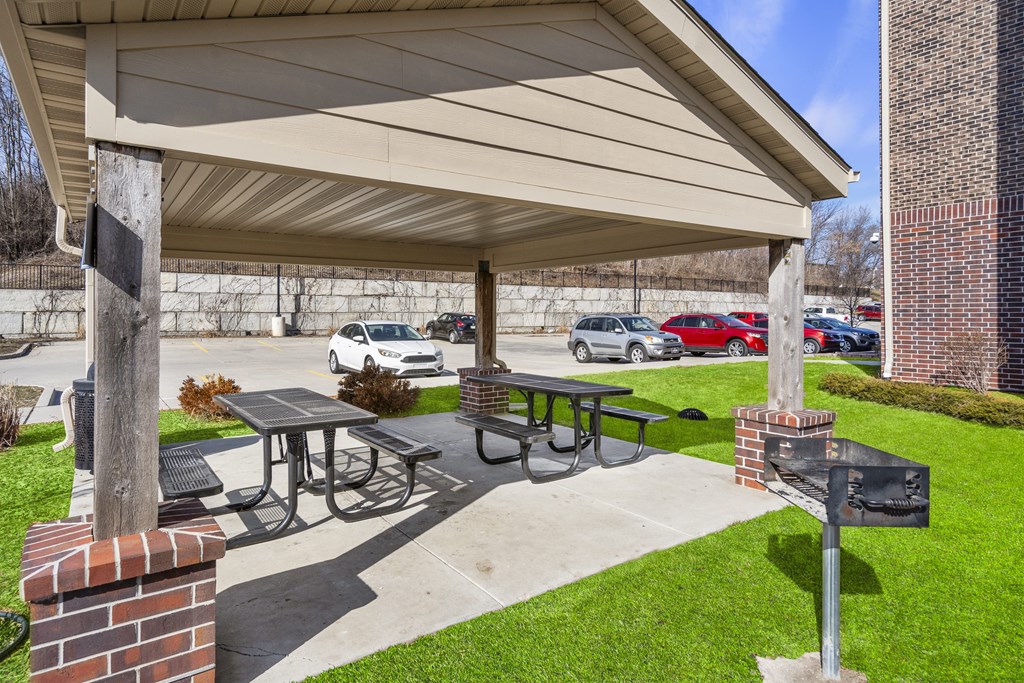 A covered picnic area with tables and a grill.