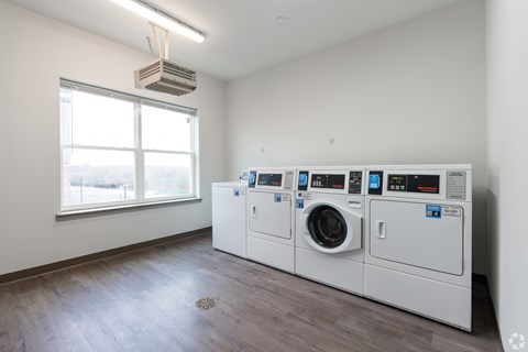 A room with a window and a washing machine.