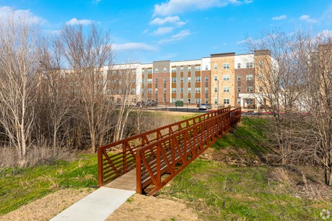 A bridge leads to a building with a yellow and white facade.