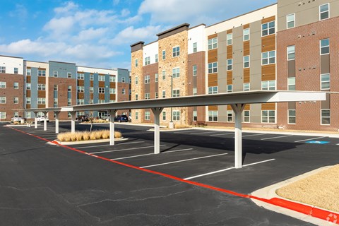 A parking lot in front of a multi-story building.