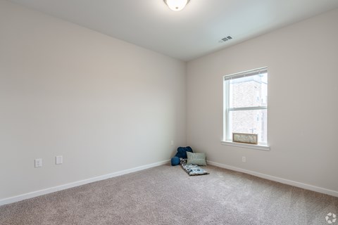 A room with a window and a carpet on the floor.