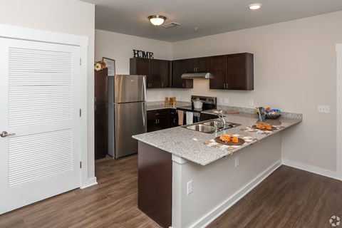 A kitchen with a granite counter top and stainless steel appliances.