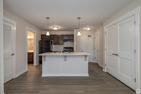 A kitchen with a white island and wooden floors.