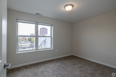 A room with a window overlooking a cityscape.