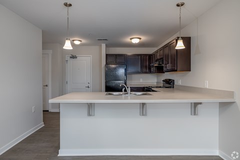 A kitchen with a white island and black cabinets.
