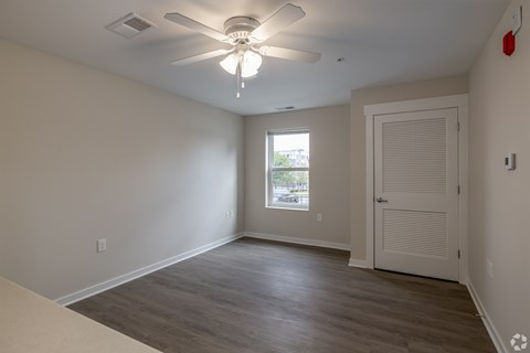 A room with a ceiling fan and a door.