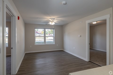 A room with a ceiling fan and a window with a view of the outside.