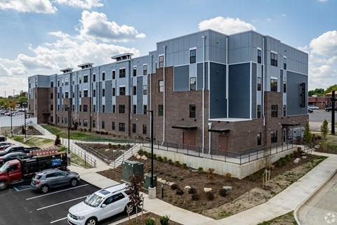 A modern building with a parking lot in front.