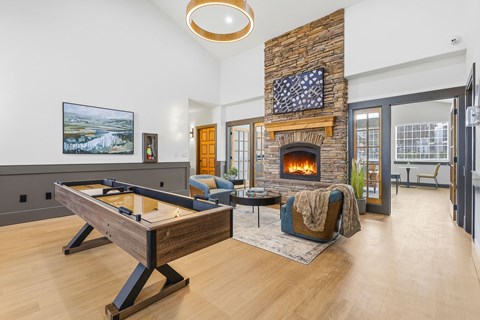 A room with a pool table and a fireplace.