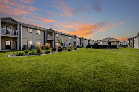 A row of houses with a green lawn in front.