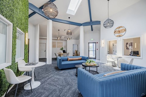 A living room with a blue couch and a green wall.