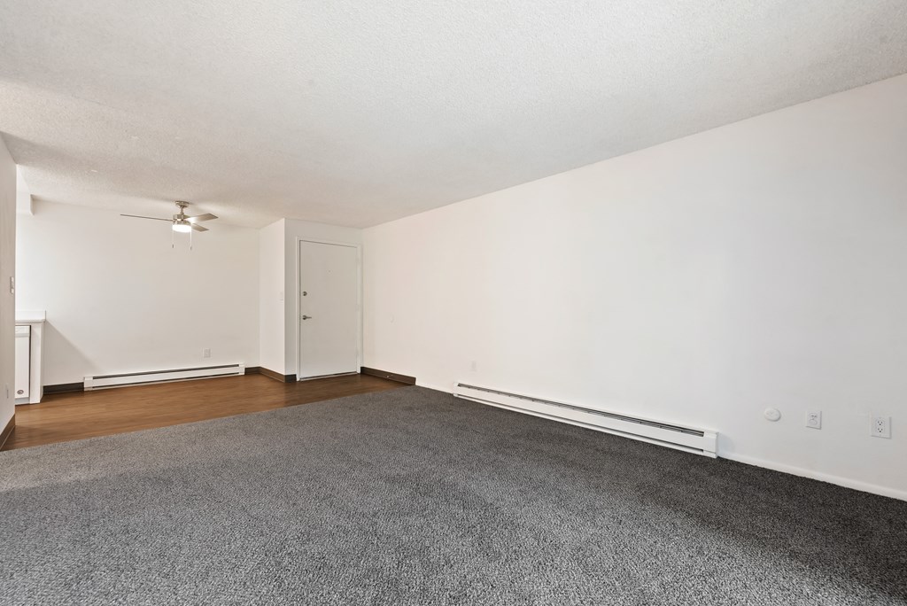 an empty living room with hardwood floors and white walls