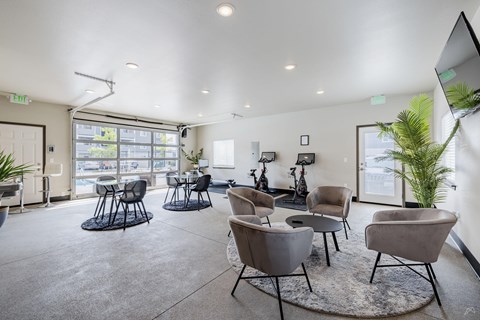 A spacious waiting room with grey chairs and a large window.