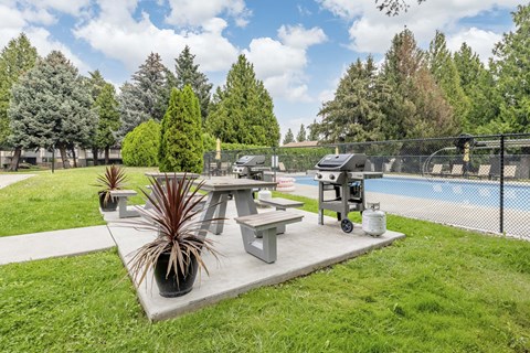 A backyard with a pool and a picnic table.