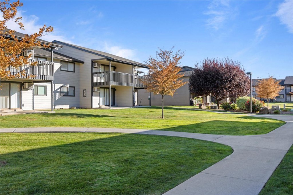 Exterior apartments with balconies and sidewalks through the bright green grass and well-maintained landscaping. at Brix, Walla Walla, WA, 99362