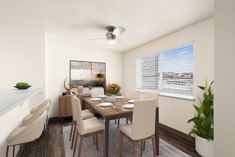 Bright dining area with a large window on the right wall, ceiling fan, and breakfast bar to the left. Staged with a dining table, chairs, plants, and art.at Clearwater, Idaho