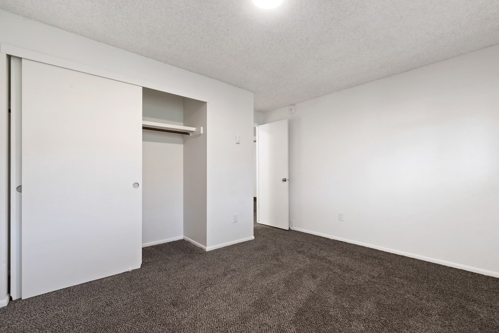 an empty living room with carpet and white walls
