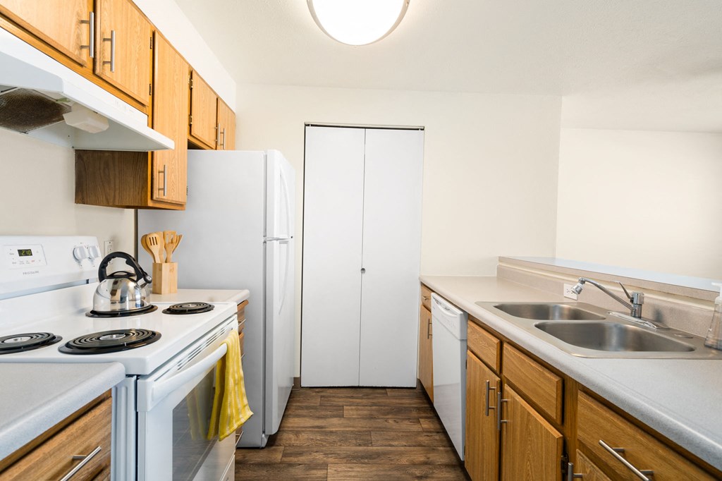 The galley-style kitchen has white appliances, a stainless steel sink, and an accordion door pantry on the back wall.at Clearwater, Idaho