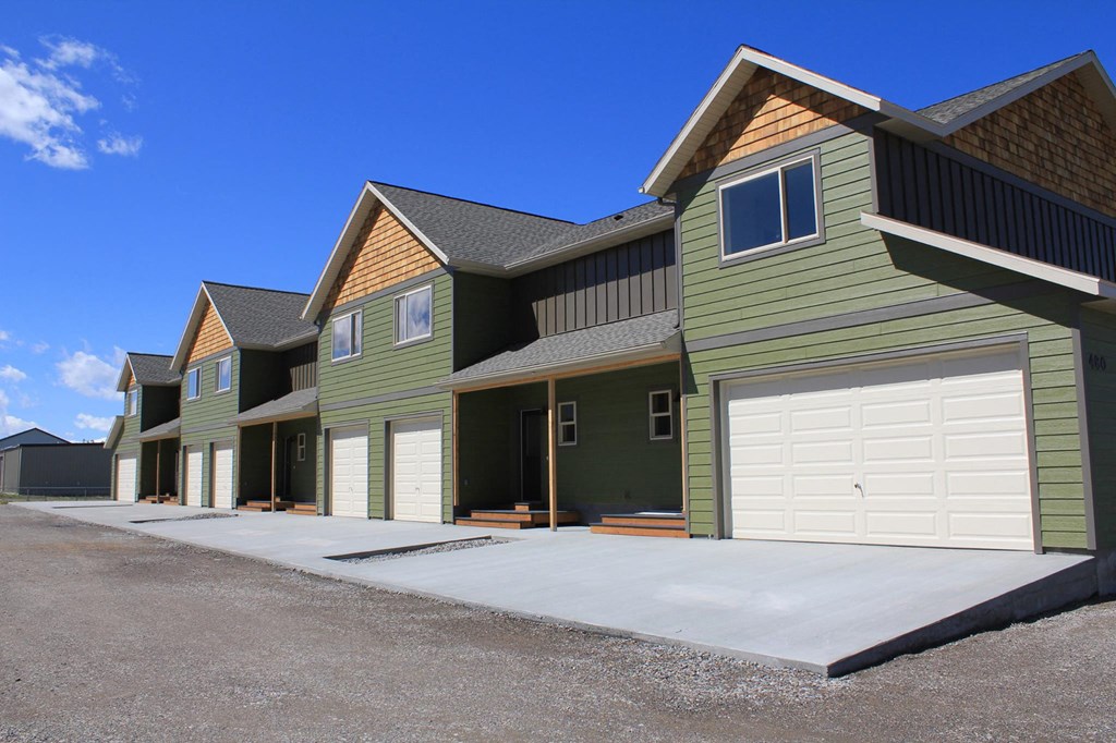 a row of green houses with white garage doorsat Copper Pines, Bozeman, 59718