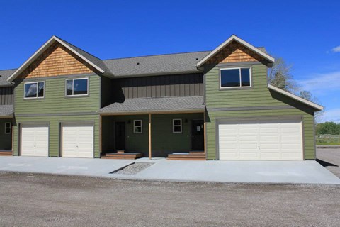 the front of a green house with two garage doors at Copper Pines, Bozeman, MT